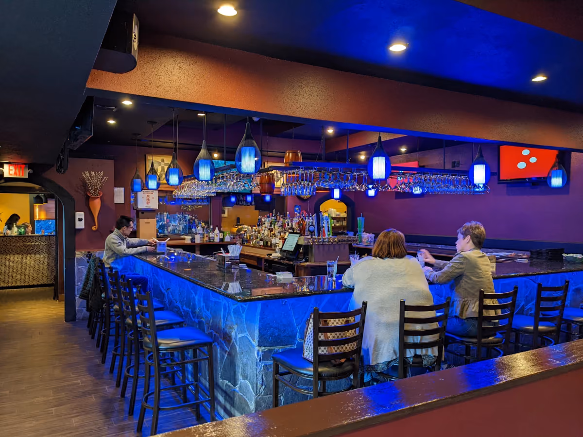 The dining room at Mido Sushi, with a blue lit bar