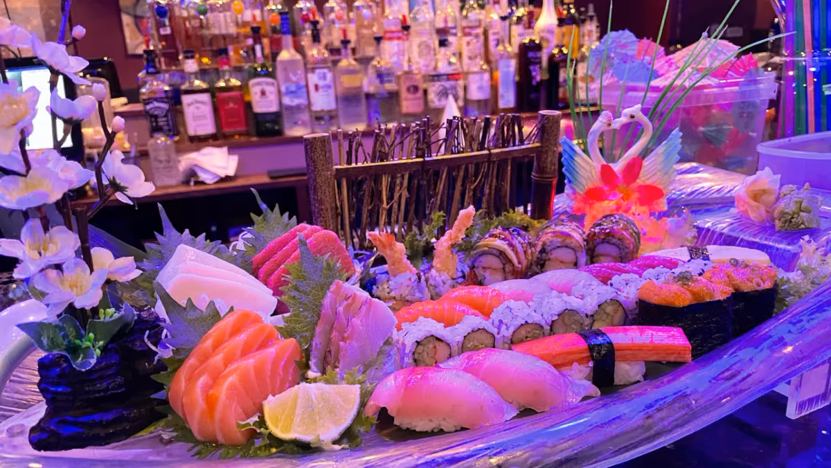 A sushi and sashimi boat with colorful garnishes at Mido Sushi