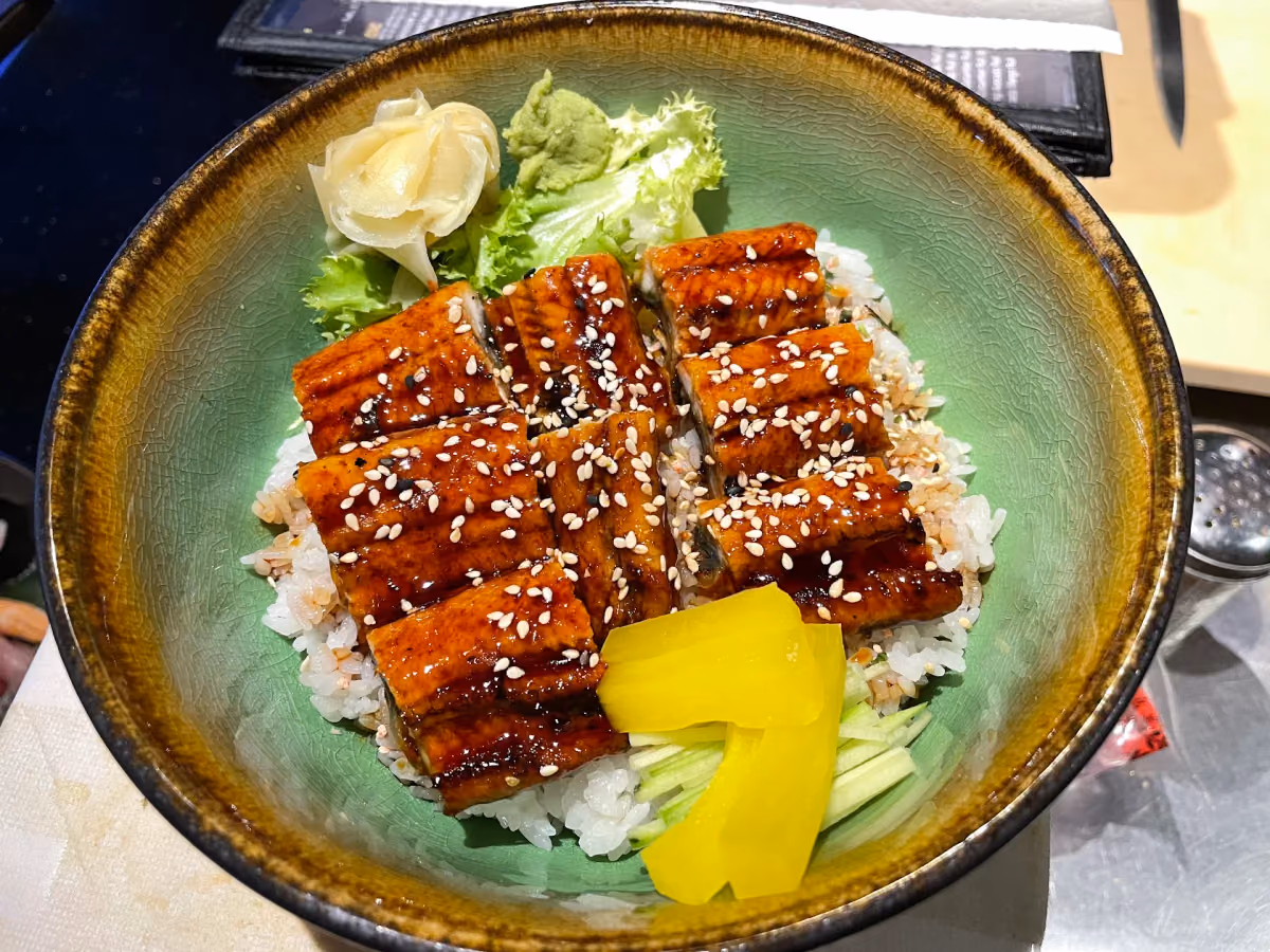Glazed grilled eel over rice with sesame seeds and pickled vegetables